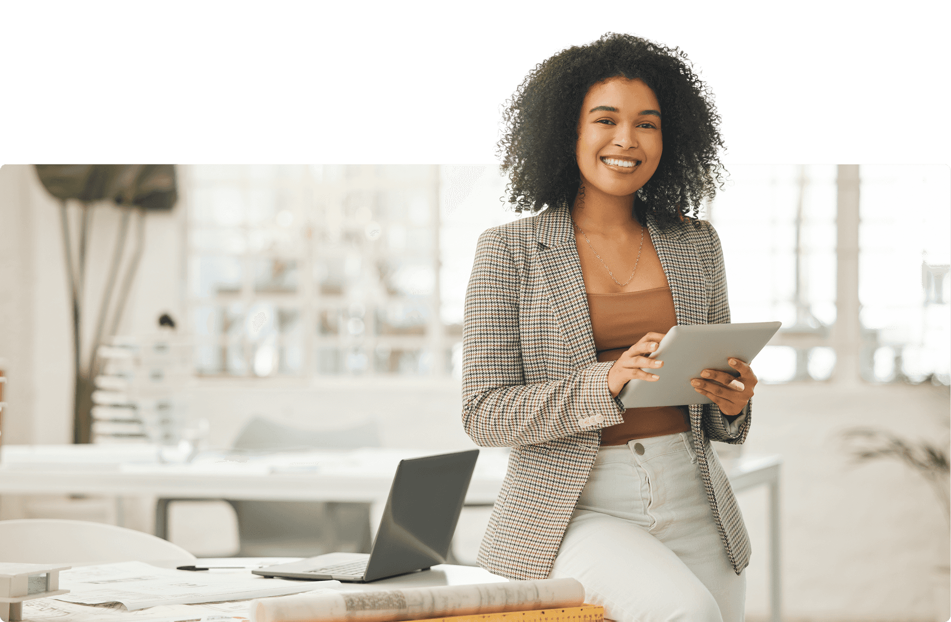 Mulher sorridente com tablet a beira de uma mesa